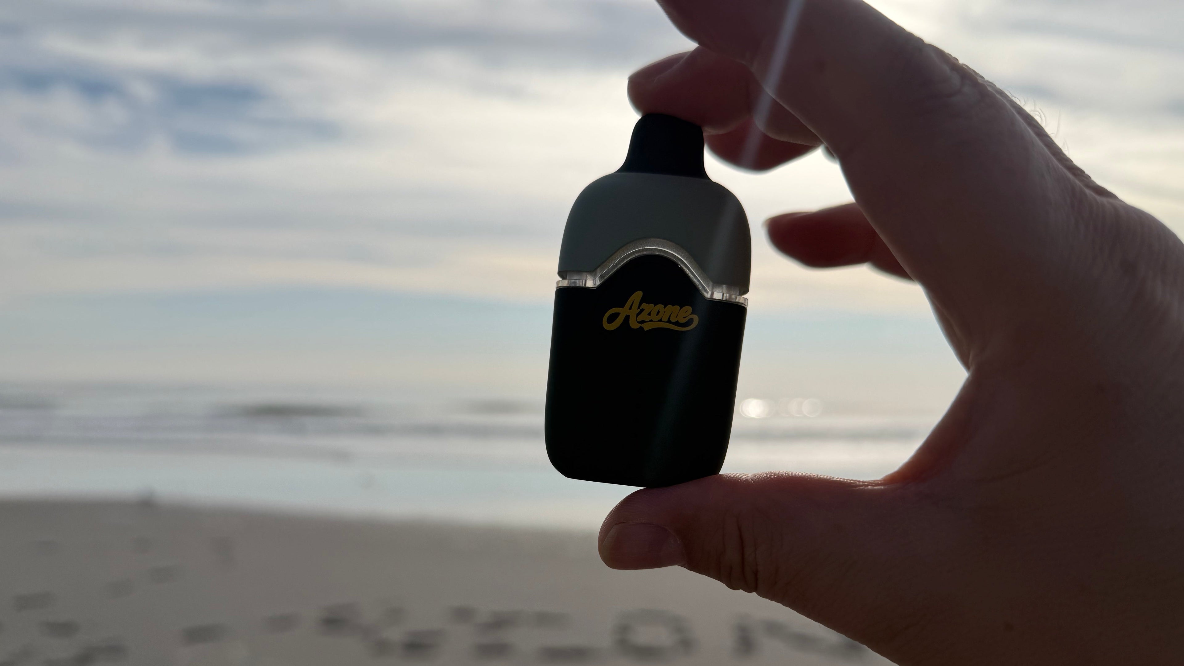 Hand holding a blue and gold azone product with 'Gator' branding against a blurred outdoor background.